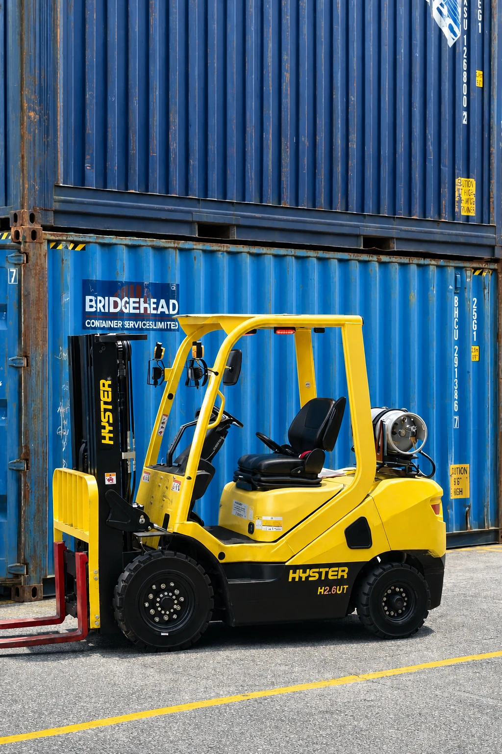 Yellow forklift working beside shipping containers